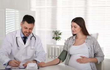 Doctor measuring blood pressure of pregnant woman